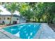 A clear blue pool is surrounded by mature trees and concrete decking at 1501 7Th Se St, Winter Haven, FL 33880