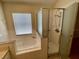 Bathroom featuring separate shower and tub with tile surround and window at 1003 Clearpointe Way, Lakeland, FL 33813