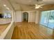 Open-concept living room with hardwood floors, columns, and sliding glass doors to the lanai at 1003 Clearpointe Way, Lakeland, FL 33813