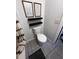 Close-up of a toilet with artwork and shelves, positioned in a well-lit bathroom with tile flooring at 6762 Pomeroy Cir, Orlando, FL 32810