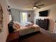 Cozy bedroom with a ceiling fan, TV, dresser and a large window that brings in natural light at 6762 Pomeroy Cir, Orlando, FL 32810