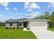 Charming single-story home with a well-manicured lawn, attached garage, and freshly painted exterior at 1204 Alafia Way, Kissimmee, FL 34759
