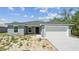 A simple single-story home with an attached garage and a freshly painted exterior at 1204 Alafia Way, Kissimmee, FL 34759