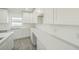 Bright kitchen featuring white cabinetry, granite countertops, modern appliances, and wood-look flooring at 1204 Alafia Way, Kissimmee, FL 34759