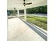 Large concrete back porch features ceiling fans and views of the green backyard and surrounding woods at 13619 Sw 78Th Pl, Dunnellon, FL 34432