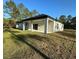 Home's exterior shows covered back porch, sliding glass doors, and a spacious, well-maintained lawn at 13619 Sw 78Th Pl, Dunnellon, FL 34432