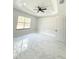 Bright bedroom featuring marble floors, a large window, and modern ceiling fan at 13619 Sw 78Th Pl, Dunnellon, FL 34432