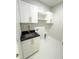 Well-lit laundry room with stainless steel sink, black granite countertop, white cabinets, and shelving at 13619 Sw 78Th Pl, Dunnellon, FL 34432