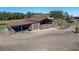An exterior perspective of the horse barn, featuring distinct markings and a sand paddock at 6820 County Road 561, Clermont, FL 34714