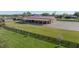 Exterior view of the spacious barn with a metal roof, open-air stalls, and expansive grassy surroundings at 6820 County Road 561, Clermont, FL 34714