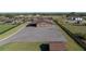 Aerial view showcasing the barn with ample parking, a paved driveway, and fenced pasture in the countryside at 6820 County Road 561, Clermont, FL 34714