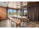 Bright dining area with rustic wooden table and benches, wood-paneled walls, and large windows at 6820 County Road 561, Clermont, FL 34714