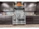 Close up of stainless steel gas range with attractive vent hood and unique counter tops at 6820 County Road 561, Clermont, FL 34714