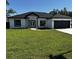 Charming single story home featuring a manicured lawn, gray and white exterior paint, and a black asphalt shingle roof at 8456 Se 164Th Pl, Summerfield, FL 34491