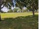 Property boasts a vast grassy lawn, framed by mature trees at 5352 Treasure View Way, Leesburg, FL 34748