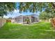 Lush backyard with mature trees showcases a screened pool area, offering privacy and relaxation at 1125 English Garden Ln, Winter Garden, FL 34787
