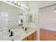 Bathroom with double sinks, large mirrors, and access to a bathtub room and the bedroom at 1125 English Garden Ln, Winter Garden, FL 34787