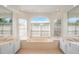 Sunlit bathroom featuring double sinks, large mirrors, and a soaking tub nestled between large windows at 1125 English Garden Ln, Winter Garden, FL 34787