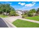 Charming home featuring mature landscaping, a paver driveway, and a manicured lawn at 1125 English Garden Ln, Winter Garden, FL 34787
