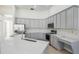 Bright kitchen featuring gray cabinetry, stainless steel appliances, quartz counters, and a functional built-in desk area at 1125 English Garden Ln, Winter Garden, FL 34787