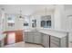 Open-concept kitchen with light gray cabinets, quartz countertop, stainless dishwasher, and seamless flow into the living space at 1125 English Garden Ln, Winter Garden, FL 34787