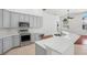 Modern kitchen boasts gray cabinets, stainless steel appliances, and a stylish quartz countertop with breakfast bar at 1125 English Garden Ln, Winter Garden, FL 34787