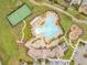 Aerial view showcases a community pool, tennis court, playground, and clubhouse at 11865 Ginsberg Pl, Orlando, FL 32832