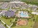 Aerial view shows a community clubhouse, pool, and playground near residential homes and a pond at 11865 Ginsberg Pl, Orlando, FL 32832