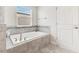 Modern bathroom featuring a large soaking tub with gray tile surround at 11865 Ginsberg Pl, Orlando, FL 32832