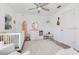 Bright Bedroom featuring a ceiling fan, crib, surf board, and beach-themed decorations for a serene space at 11865 Ginsberg Pl, Orlando, FL 32832