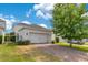 Well-maintained home exterior showing a two-car garage, green lawn, and mature landscaping at 11865 Ginsberg Pl, Orlando, FL 32832