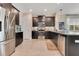 Modern kitchen with stainless steel appliances, dark cabinetry, granite countertops, and tile backsplash at 11865 Ginsberg Pl, Orlando, FL 32832