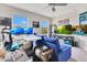 Bright living room featuring a comfortable blue sofa, carpet flooring and two large windows at 11865 Ginsberg Pl, Orlando, FL 32832