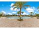 Community pool with palm trees and lounge chairs under a blue sky at 11865 Ginsberg Pl, Orlando, FL 32832
