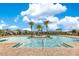 Community pool surrounded by palm trees under a bright blue sky at 11865 Ginsberg Pl, Orlando, FL 32832
