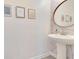 Charming powder room featuring stylish wallpaper and a modern pedestal sink at 11865 Ginsberg Pl, Orlando, FL 32832
