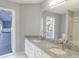 Bathroom featuring dual sinks with granite countertops and a view of the pool at 3955 Sw 139Th Street Rd, Ocala, FL 34473