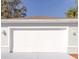 Spacious two-car garage with a white door and modern exterior lighting at 3955 Sw 139Th Street Rd, Ocala, FL 34473
