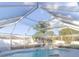 Large screened-in pool enclosure over inground pool with rock waterfall feature at 3955 Sw 139Th Street Rd, Ocala, FL 34473