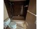 Small bathroom showcasing tiled shower, toilet and dark fixtures in need of renovation at 13026 Baltimore Woods Ln, Orlando, FL 32824