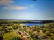 An aerial view of a neighborhood showcasing lush greenery, a lake, and well-maintained homes at 9632 Spring Lake Dr, Clermont, FL 34711