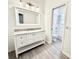 Bathroom with a white vanity with a marble top and a large mirror over the sink at 9632 Spring Lake Dr, Clermont, FL 34711