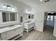 Bathroom featuring dual sinks with white cabinets and views to other rooms in the home at 9632 Spring Lake Dr, Clermont, FL 34711