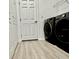 Convenient laundry room area featuring a washer and dryer next to shelving and a door at 9632 Spring Lake Dr, Clermont, FL 34711