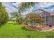 A lush backyard features a screened-in patio with a swimming pool and tropical landscaping at 508 Bacio St, New Smyrna Beach, FL 32168