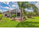 The landscaped backyard includes a screened-in patio with a swimming pool and palm trees at 508 Bacio St, New Smyrna Beach, FL 32168