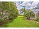 Beautiful backyard featuring lush lawn, verdant trees, and manicured landscaping for serene outdoor living at 508 Bacio St, New Smyrna Beach, FL 32168