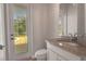 Bathroom with granite countertop vanity, tile flooring, and access to an outdoor patio at 508 Bacio St, New Smyrna Beach, FL 32168