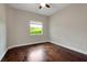 Bright bedroom featuring hardwood floors, a ceiling fan, and natural light from the window at 508 Bacio St, New Smyrna Beach, FL 32168