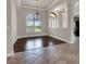 Inviting foyer with tile and hardwood flooring, arched doorways, large window with wooden blinds and a chandelier at 508 Bacio St, New Smyrna Beach, FL 32168